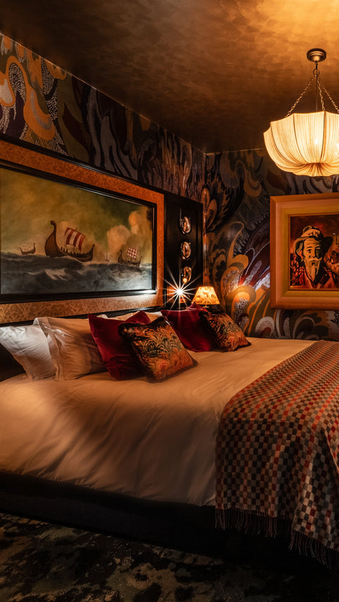 Ardbeg House Rebel bedroom with patterned walls, bed, and various decorative items.